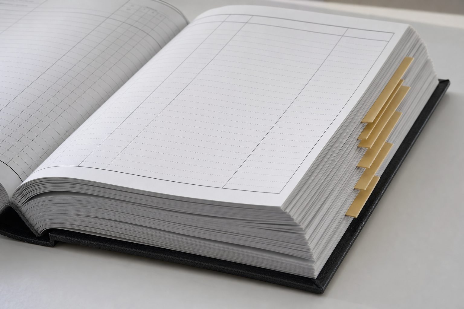 A binder of ledger pages fanned open showing dotted rules and yellow tab dividers on a white surface